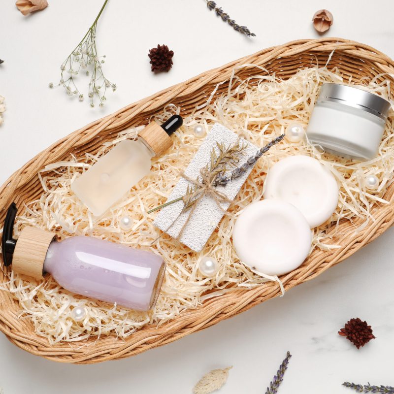 Spa gift set with different personal care products on white marble table, flat lay